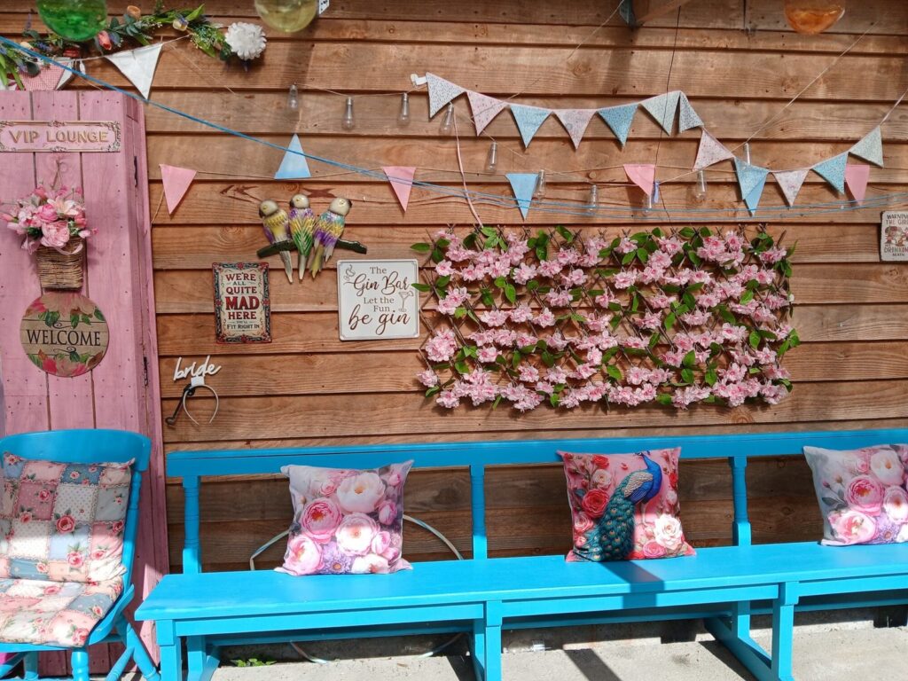 Flower wall and benches decorated for a hen party at Hen Party Glamping